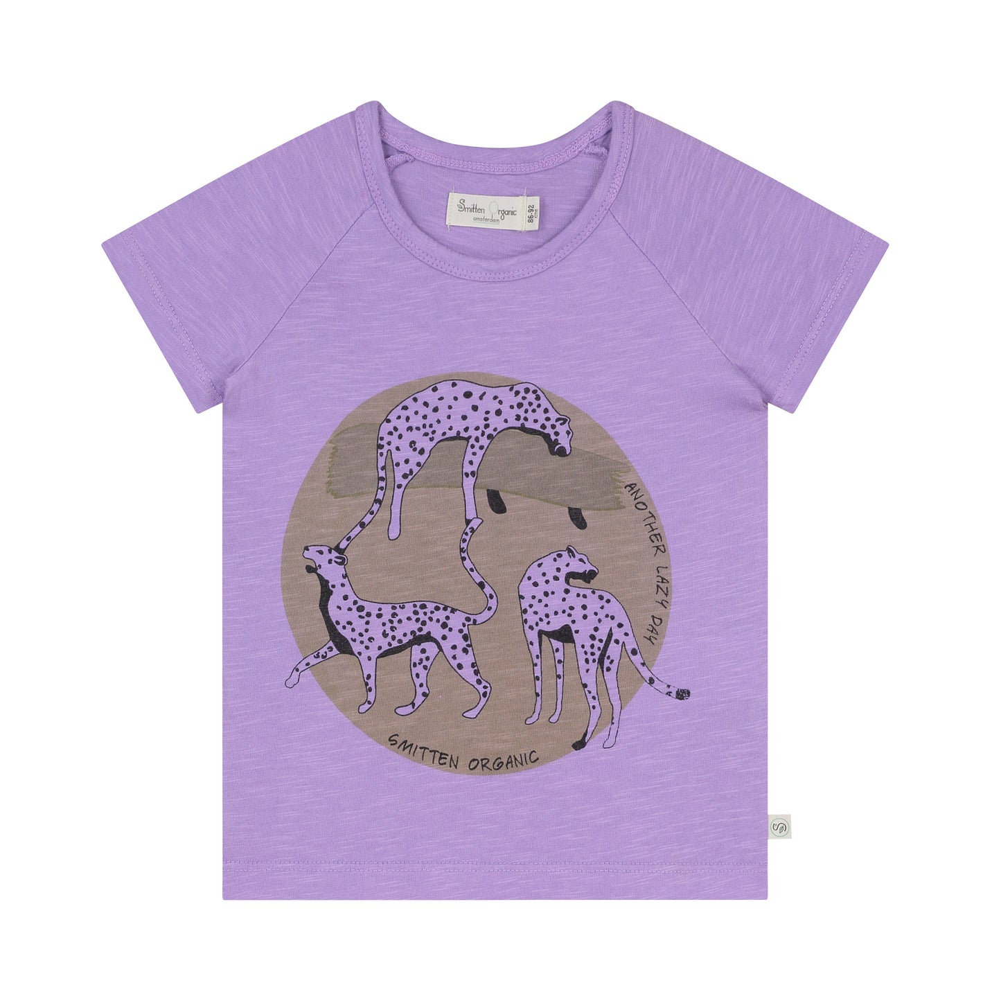 Sprung des Leoparden, der am purpurroten T-Shirt des Kurzarms der Akazie liegt