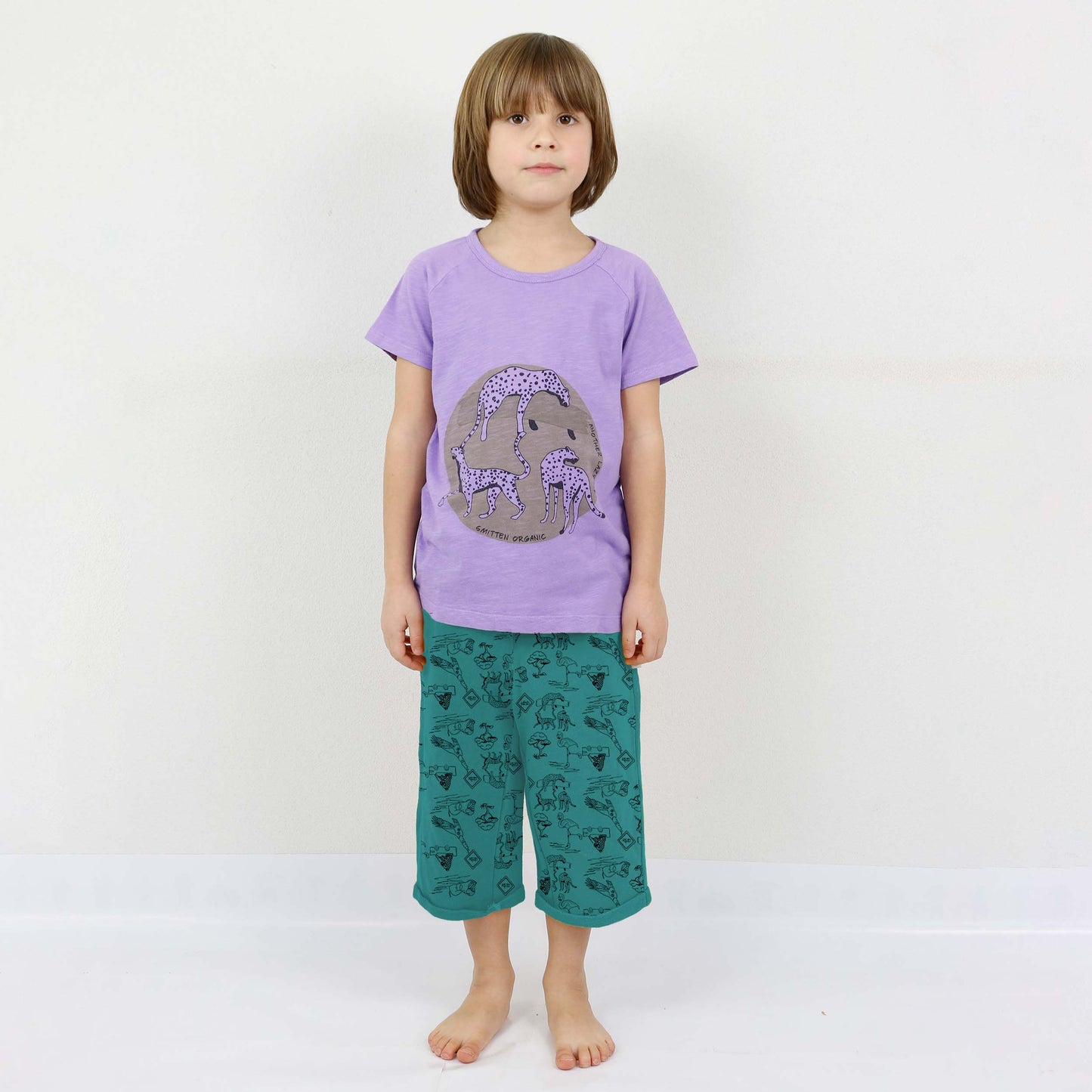 Sprung des Leoparden, der am purpurroten T-Shirt des Kurzarms der Akazie liegt